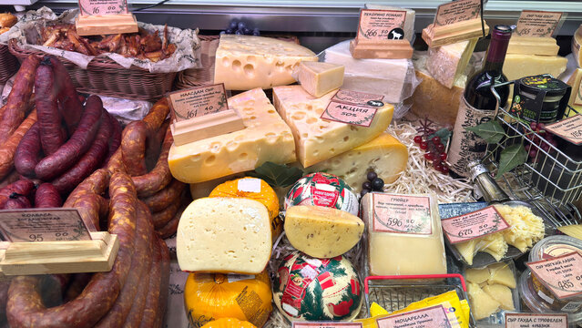 Assortment of cheeses at rustic market display. Various types of cheese. Cured sausages. For Wine food lovers. Local dairy and farm products in the store.