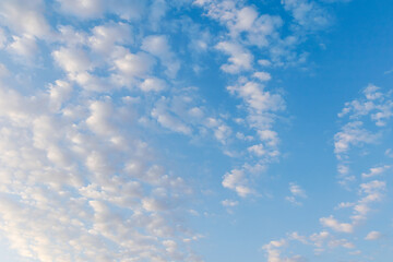 Scattered white clouds in a blue sky