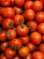 Fresh red tomatoes piled together in a farmer's market showcasing vibrant produce