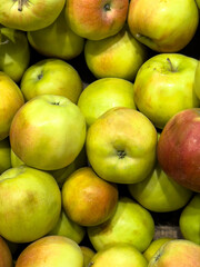 Freshly picked green and yellow apples piled together at a local market during late autumn harvest season