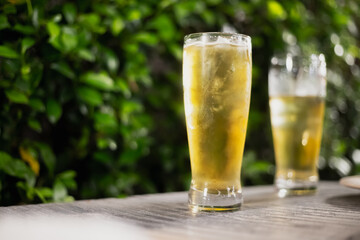 Beer glass on wooden board . Blurred background party party. Cold beer.
