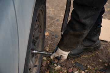 Changing a wheel. Close-up of loosening and tightening wheel bolts. Seasonal tire change. Part of...