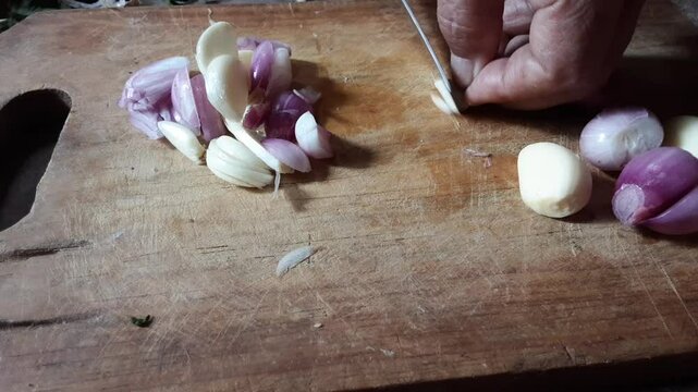Slicing onions and  garlic on a wooden background