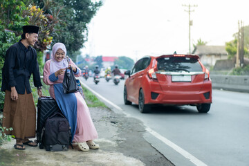 asian muslim couple with suitcase prepare to go. concept of man and woman travelling for eid mubarak celebration