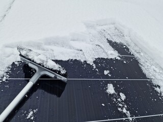 Freifegen von einem schneebedeckten PV-Modul.