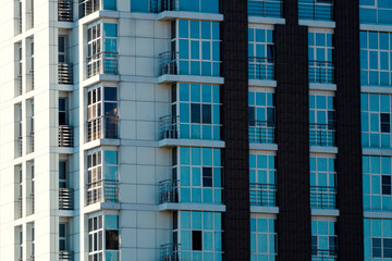 Fototapeta premium Multi-storey buildings made of glass and concrete close-up. Toned