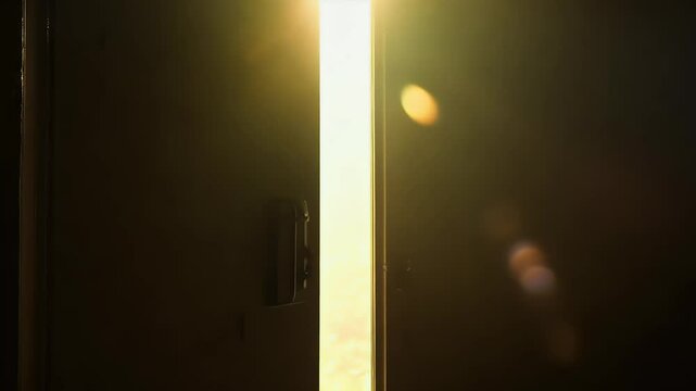 Cinematic footage dark room where mysterious door slowly opens revealing brightly lit space suspenseful zoom shot