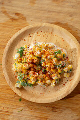 A top down view of a plate of esquites.