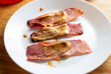 A view of a plate of peanut butter turkey bacon.