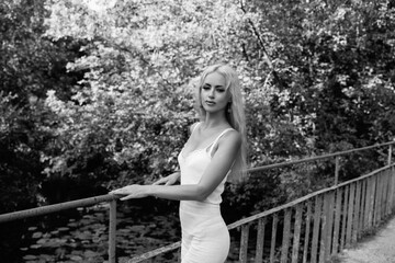 Portrait of a young beautiful blonde girl in nature. Black and white photo.