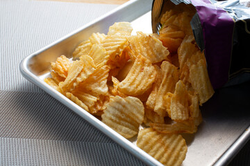 A view of ridged potato chips spilling out of a package.