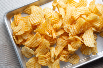 A top down view of a tray of ridged potato chips.