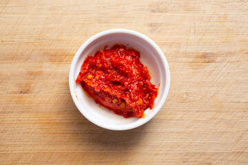 A top down view of a condiment cup of harissa.