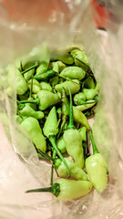 A close-up view of fresh green chili peppers in a plastic bag, ideal for cooking spicy dishes or as an ingredient for traditional Indonesian sambal
