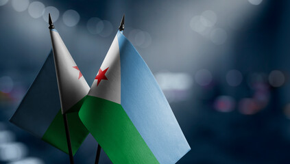 Small flags of the Djibouti on an abstract blurry background