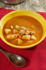 A view of a yellow bowl of chicken chipotle soup.