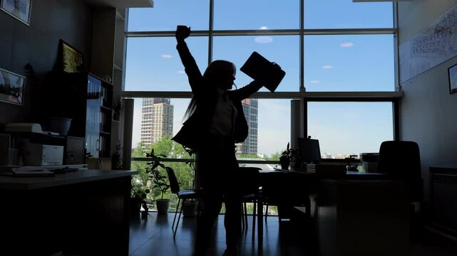 Woman celebrates success at work by dancing in office expressing emotions and joy dynamic lifestyle. Shadowy silhouette of female dances in office reflecting joy enthusiasm successful workday.