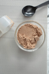 A top down view of a some protein powder in a small glass bowl.