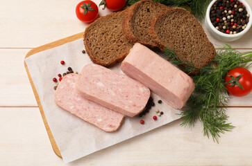Pieces of tasty canned meat, tomatoes, peppercorns, dill and bread on light wooden table, flat lay