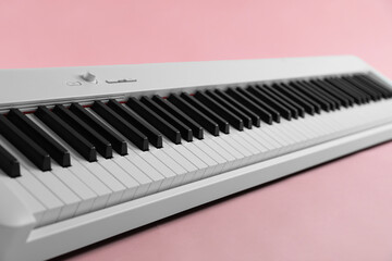 Synthesizer on pink background, closeup. Electronic musical instrument