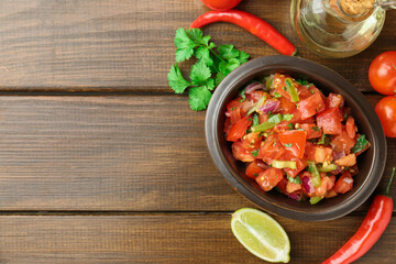 Delicious spicy salsa with ingredients on wooden table, flat lay. Space for text
