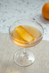 A view of an orange peel garnish in a whiskey cocktail glass.
