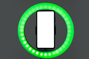 Ring lamp with smartphone on grey background, closeup
