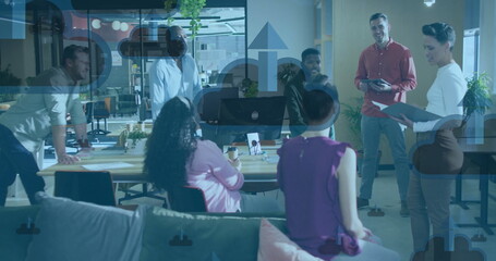 Image of clouds with arrows icons over diverse colleagues talking in office