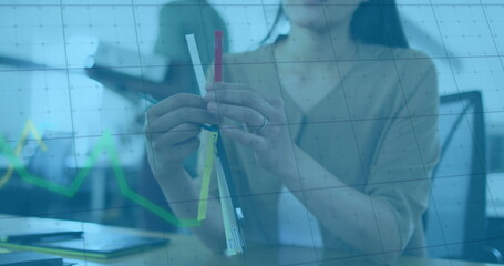 Image of financial data processing over asian businesswoman holding samples