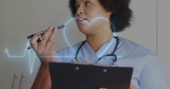 Image of cardiograph and heart over biracial female nurse talking on smartphone