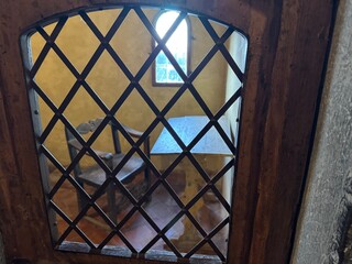 Cella di un monastero vista attraverso un'inferriata
