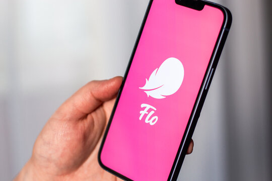 Kaliningrad, Russia 14.01.25 - Woman holding smartphone with FLO application logo on screen. Controlling woman period, ovulation, pregnancy. Female health concept.