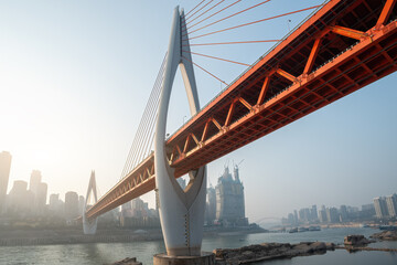 Obraz premium Modern Urban Bridge Against a Sunrise Skyline with River Reflection