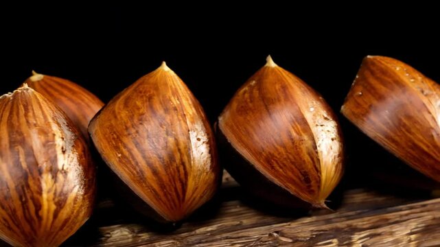 Dramatic side lighting video, pan left establishing scene of a line of brazil nuts displaying their large size, brown shell, in a neat row