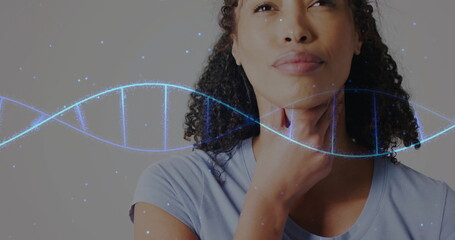 Image of dna strand over portrait of african american woman on white background