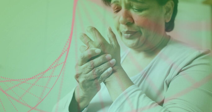 Image of dna strand over senior biracial woman holding her hand