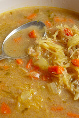 A closeup view of a spoon in a bowl of spaghetti squash soup.