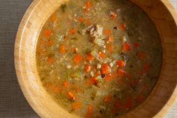 A top down view of a bamboo bowl of ground turkey soup.