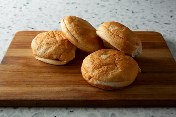 A view of pile of gluten-free burger buns.