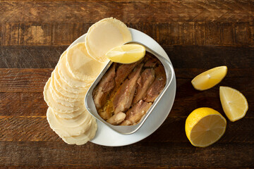 A top down view of an appetizer of canned sardines and crackers.