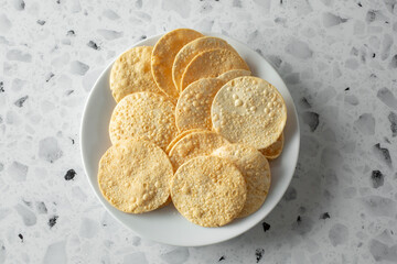 A top down view of a pile of papadam chips.