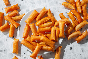 A top down view of a pile of baked pizza chips.