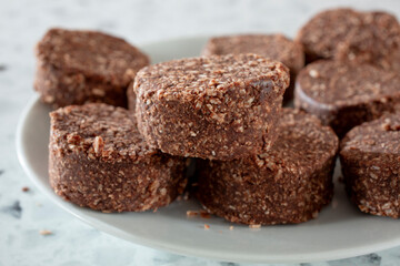 A closeup view of a pile of chocolate coconut cookies.