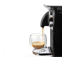 Process of making coffee by coffee machine into glass transparent cup - espresso coffee coming out from home coffemaker machine. Capsule coffee by machine isolated on white