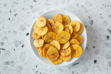 A top down view of a plate of plantain chips.