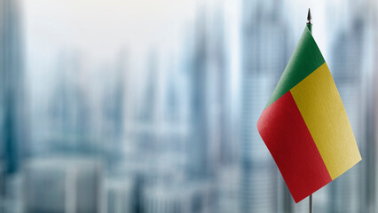 Small flags of the Benin on an abstract blurry background