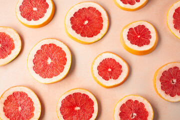 A top down view of scattered slices of red grapefruit, as a background.