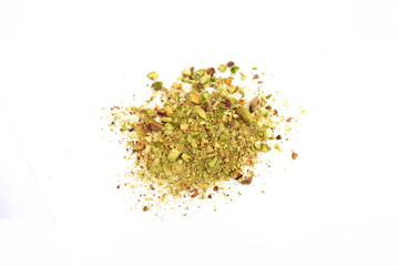 Ground, milled, crushed or granulated pistachio pile isolated on white background. Scattered pistachio nut pieces isolated. Break chopped pistachios pile, fried baked diced pistache on white backgroun