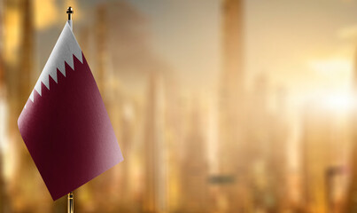 Small flags of the Qatar on an abstract blurry background