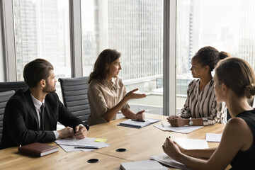 Group of multiethnic businesspeople met in conference room in high-rise office, discuss strategy,...